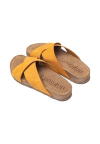 Gelbe Wildleder-Sandalen mit überkreuzten Riemen, einem Korkfußbett und einer strukturierten Sohle; weiche Innenauskleidung mit bedrucktem Logo.