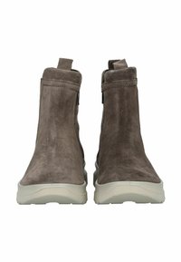 Botines de ante marrón con una textura suave, paneles laterales elásticos y suelas de goma, con una punta redondeada y un diseño minimalista.