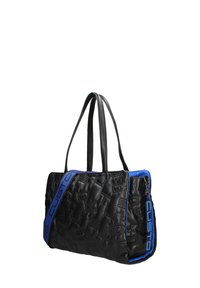 Sac cabas matelassé noir avec motifs en relief, présentant des accents bleus et des poignées, et un détail de fermeture éclair argentée sur un côté.