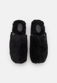 Zwarte fuzzy slippers met een zachte, textuur buitenkant en een open achterkant. Ze hebben een platte zool en een pluizige voering voor comfort.