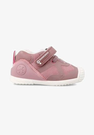 Zapato infantil rosa con una combinación de materiales suaves y de malla, correa de Velcro, puntera redondeada y suela de goma blanca.