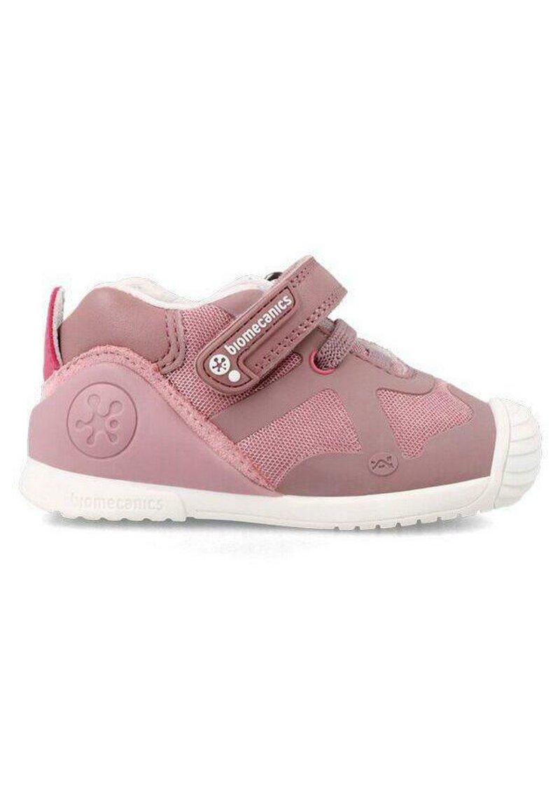 Zapato infantil rosa con una combinación de materiales suaves y de malla, correa de Velcro, puntera redondeada y suela de goma blanca.