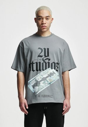Gray oversized t-shirt with black graphic text and a printed $100 bill design. Short sleeves and a round neckline, made of cotton.