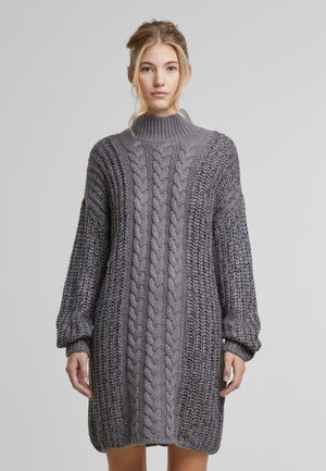 Graues gestricktes Sweatkleid mit hohem Kragen, ausgestattet mit dicken Kabelmustern und langen, leicht puffigen Ärmeln. Weicher Stoff und lässige Passform.