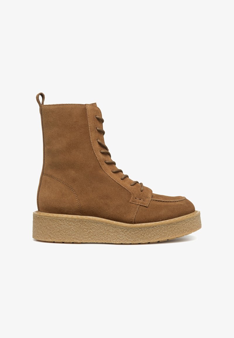 Stivale alla caviglia in suede marrone con suola in gomma spessa e strutturata, lacci anteriori e linguetta a ciclo sul retro. Design a punta rotonda.