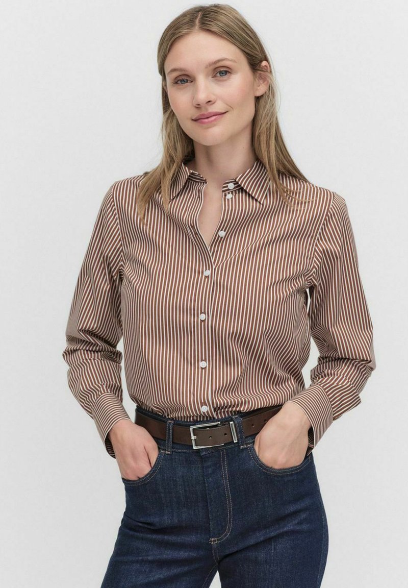 Chemise boutonnée à rayures marron et blanches avec un col. Les manches sont retroussées, mettant en avant une texture lisse et une coupe ajustée.