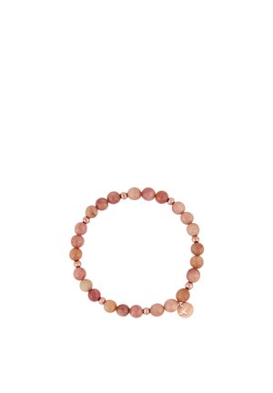 Stretchy bracelet with alternating smooth round pink beads and small metallic beads, featuring a round metallic charm with a cross cutout.