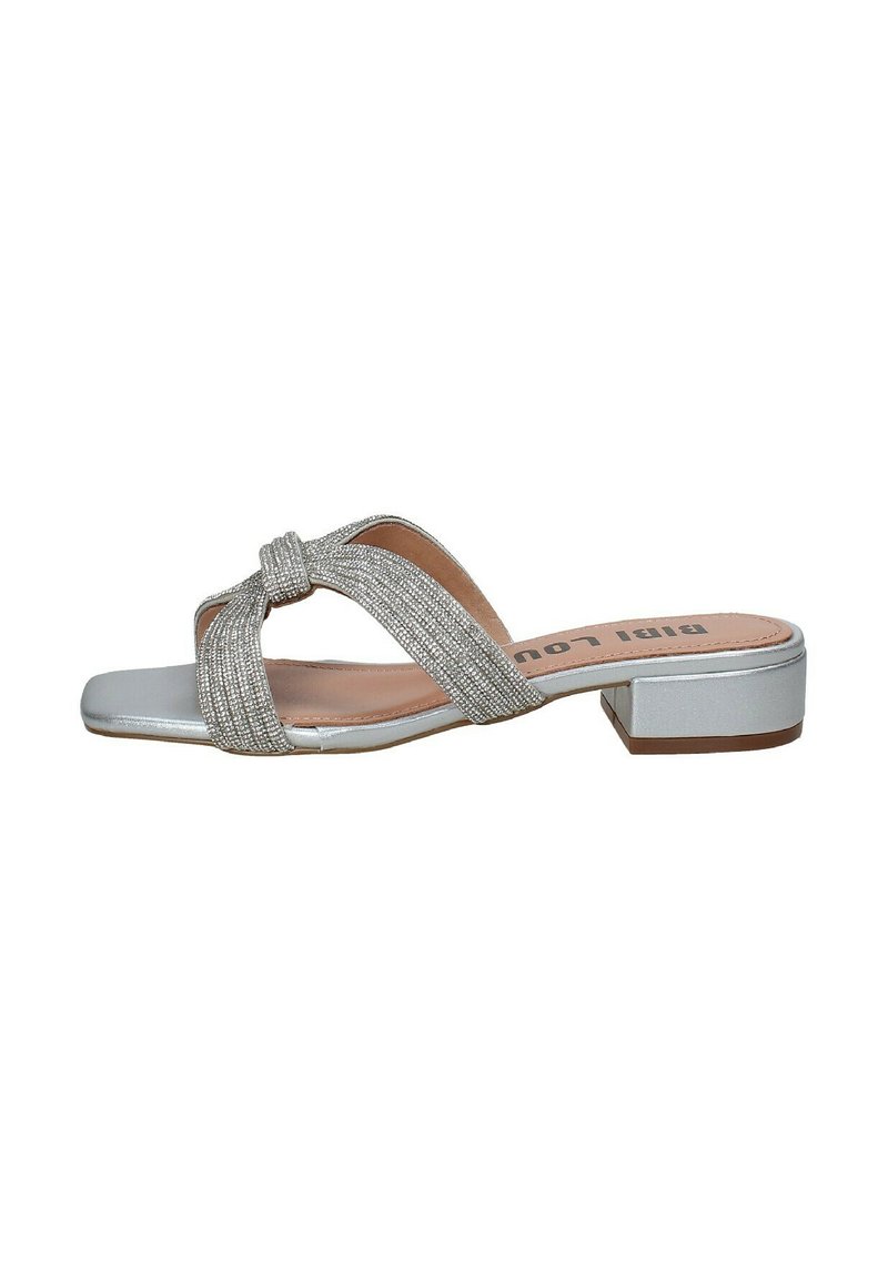 Zilveren platte slidersandalen met gekruiste, gestructureerde banden en een kleine blokhak. Gladde zool en lichtroze binnenzool. Eenvoudig, modern ontwerp.