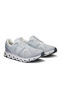 Hellgraue Sportschuhe mit einem Obermaterial aus Mesh, gepolstertem Schaft, weißer Sohle mit strategischen Ausschnitten und einer grauen Zehenkappe.