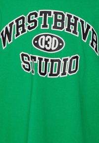 Groene katoenen t-shirt met opvallende zwart-witte tekst: "WRSTBHVRS 03D STUDIO." Eenvoudige ronde hals en een ontspannen pasvorm.