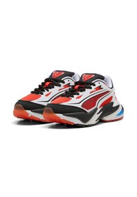 Par de zapatillas deportivas de corte bajo con acentos en blanco, rojo, negro y azul, cordones negros y detalles de tela de malla sobre un fondo blanco.