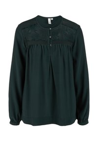 Blouse manches longues vert foncé avec des détails en dentelle sur le haut de la poitrine, col rond et trois petits boutons sur le devant.