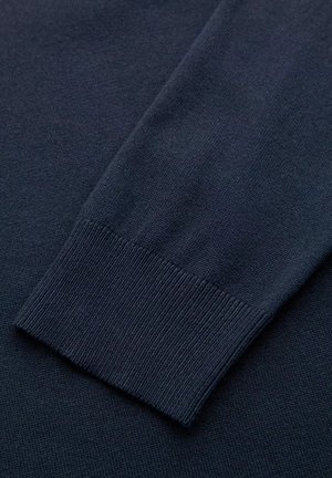 Manche de pull en tricot bleu marine avec un poignet côtelé. Texture douce avec une finition lisse. Lignes épurées et motif uniforme sur l'ensemble.