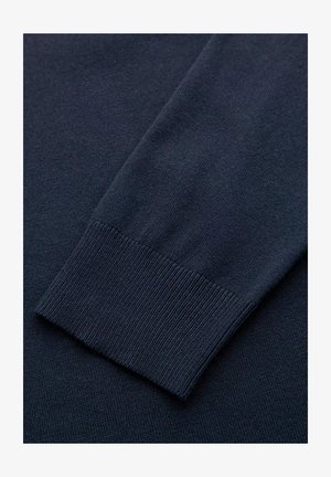 Niebieska sweter pleciony z marynarskim rękawem i ściągaczem. Miękka tekstura o gładkim wykończeniu. Czyste linie i jednolity wzór w całym materiale.