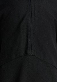 Black fabric close-up featuring smooth texture, stitched seams, and a slight sheen, showcasing a simple, minimalist design.