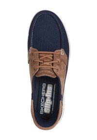 Zapato slip-on de Skechers con parte superior de lona azul marino, acentos de ante sintético marrón, cordones redondos y una plantilla suave y texturizada con espuma de memoria.