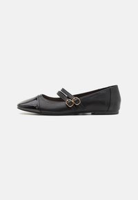 Schwarze Lederflats mit spitzem Zehenbereich, glänzenden Lackakzenten und zwei dekorativen Riemen mit goldenen Schnallen. Glatte Textur, minimalistisches Design.