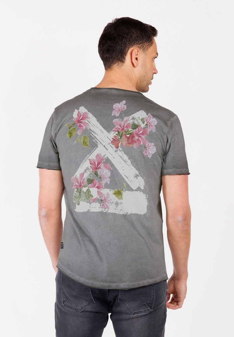 Camiseta gris de manga corta con un patrón floral en rosa y verde, y un diseño de pinceladas en la parte posterior. Material de algodón suave.