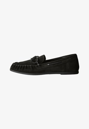 Zwarte suède mocassin platte schoen met strikdetail bovenop en gestikt ontwerp rond het teenengebied.