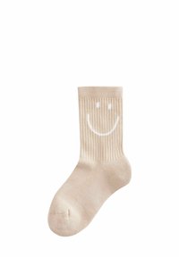 Beige Rippensocken mit einem weißen Smiley-Gesicht auf der Vorderseite. Weicher Stoff mit einem bequemen Sitz.