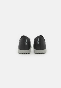 Zapatillas deportivas negras con parte superior sintética texturada, que cuentan con una suela de goma gris y una marca en el talón. Diseñadas para ofrecer comodidad y rendimiento.