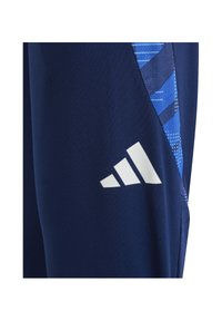 Pantalons de sport bleu foncé avec un logo Adidas blanc et une bande latérale avec un motif bleu.