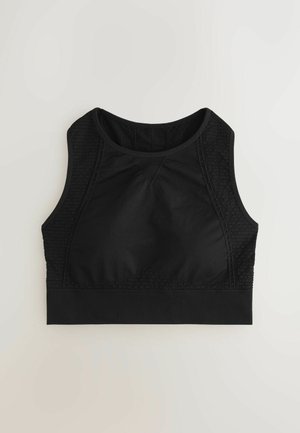 Reggiseno sportivo nero con davanti in tessuto liscio, pannelli laterali testurizzati e banda spessa in fondo. Presenta un collo alto e un design a bretelle incrociate sulla schiena.
