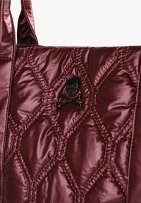 Quiltet bordeaux håndtaske lavet af skinnende materiale, med et sort dødningehoved og korsede knogler emblem i midten med kontraststing.