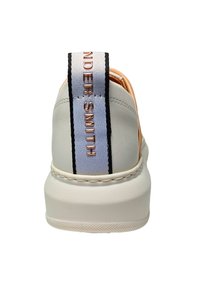 Weißer Sneaker mit glatter Oberfläche, ausgestattet mit einem rosefarbenen Akzent und einem gemusterten Zugband mit schwarz-weißen Streifen.