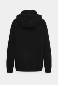 Felpa nera con cappuccio, maniche lunghe e polsini e orlo a coste. Realizzata in un tessuto morbido con una superficie liscia e senza motivi visibili.