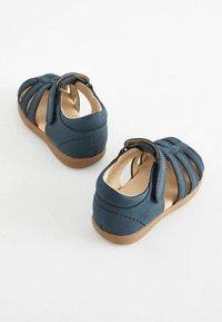 Blaue Ledersandalen mit offenem Design, verstellbaren Riemen und einer beige Gummisohle. Mit Nahtdetails und einem weichen Innenfutter.