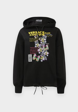 Svart hooded sweatshirt med färgglada blommor och fjärils grafik, tryckt text och dragsko i midjan. Materialet är mjukt och texturerat.