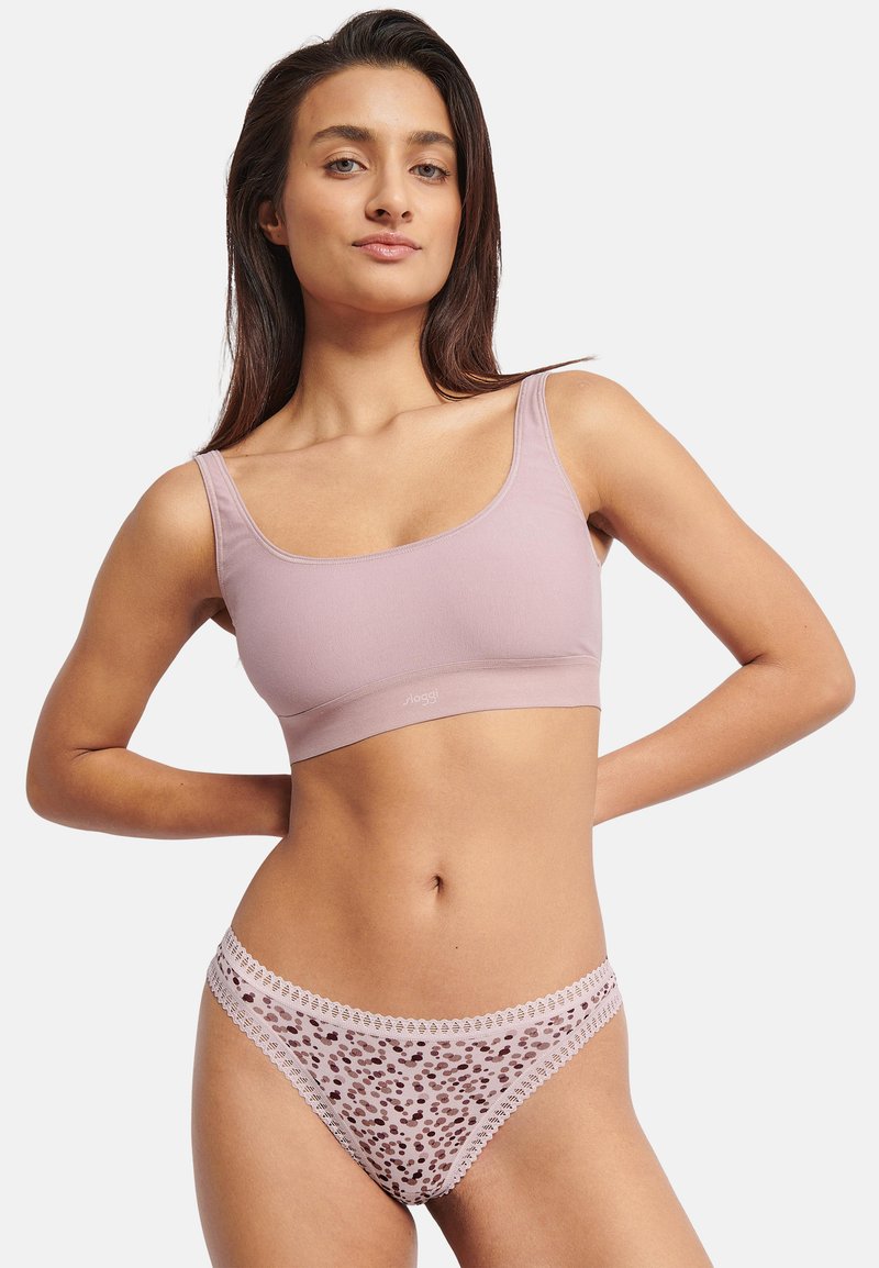 Lyserød bralette med brede stropper og glat tekstur, kombineret med matchende gennemsigtige trusser med leopardmønster og blonderkant.