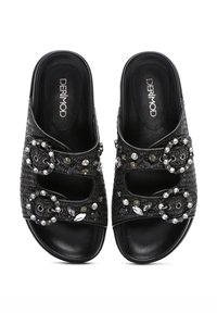 Zwarte slip-on sandalen met een textuur van geweven materiaal, versierd met grote ronde gespen en decoratieve rhinestones.