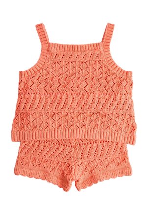 Korallys pink strikket to-delt sæt med cropped top med spaghetti-stropper og matchende højtaljede shorts med teksturerede hulmønstre.