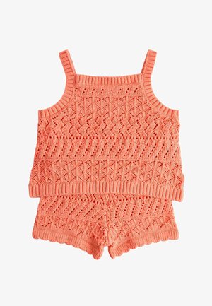 Korallys pink strikket to-delt sæt med cropped top med spaghetti-stropper og matchende højtaljede shorts med teksturerede hulmønstre.
