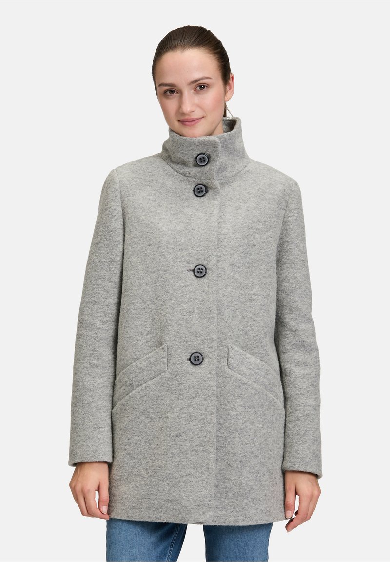 Cappotto grigio di lana con un colletto alto, chiusura frontale con bottoni e due tasche laterali. Presenta una consistenza morbida e una silhouette dritta.