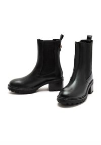 Black leather ankle boots with elastic side panels, a rounded toe, and a chunky rubber sole. Features a small heel and stitching details.