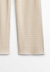 Beige geweven stoffen broek met een gestructureerd patroon van kleine, regelmatige vierkanten, rechte snit en afgewerkte zomen.