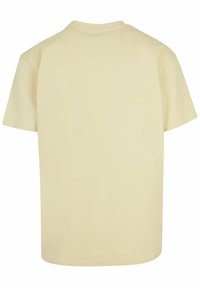 Short-sleeve t-shirt in a soft, light yellow fabric with a simple crew neckline. Smooth texture and no visible patterns or designs.
