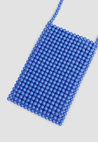 Blaue Perlen-Tasche mit rechteckiger Form, gefertigt aus runden Perlen. Verfügt über einen durchgehenden Kettenriemen und zeigt eine strukturierte Oberfläche.