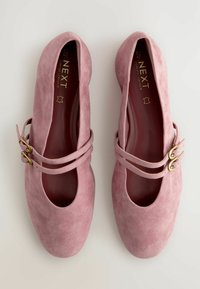 Roze suède ballerina's met een ronde neus, dubbele bandontwerpen en accenten van goudkleurig beslag. Gladde textuur en open zijkanten.