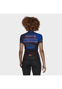 Cyklistický dres s krátkým rukávem v modré a černé barvě, s vzorem šikmých čar, zadními kapsami a červeným logem Adidas na dolní části zad.