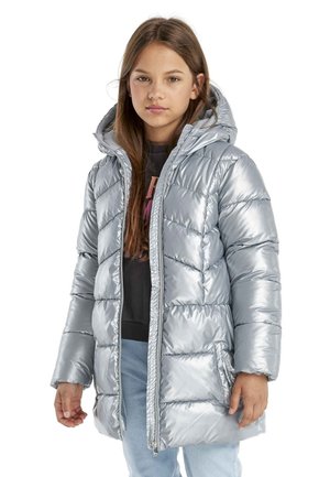 Silberne Pufferjacke mit Kapuze, die eine glänzende, gesteppte Oberfläche, einen Frontreißverschluss und eine Seitenasche aufweist; getragen über einem schwarzen Oberteil und blauen Jeans.