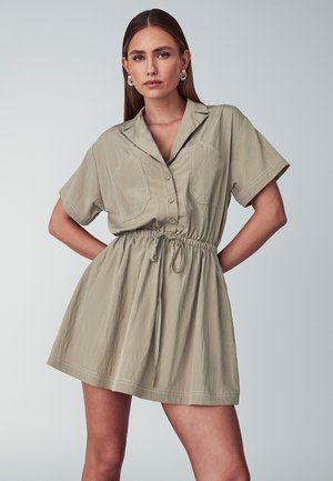 Khakifarbenes Kurzarmkleid mit durchgehender Knopfleiste, zwei Brusttaschen, Kordelzug in der Taille und weichem, strukturiertem Stoff.