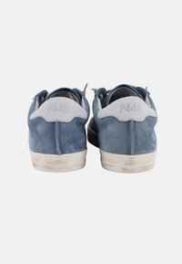 Baskets en cuir suédé bleu avec des accents blancs, de forme arrondie et avec une finition texturée. Marquage notable sur le talon et couleur de semelle contrastante.