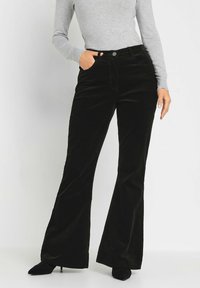 Zwarte fluwelen flared broeken met een hoge taille, voorzien van voorkruiden en een zachte textuur, gecombineerd met een grijze langemmouw top.