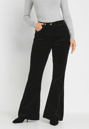 Black corduroy flared pants with a high waist, featuring front pockets and a smooth texture, paired with a gray long-sleeve top.