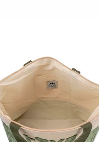 Bolso tote verde y beige con un exterior texturizado y forro de tela suave. Incluye una etiqueta y un pequeño bolsillo interior.