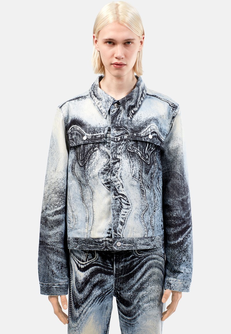 Denim jacket, jossa on abstrakti mustavalkoinen kuosi, napitus ja klassinen kaulusdesign. Rakenteellinen kangas, jossa on hieman haalistunut pinta.